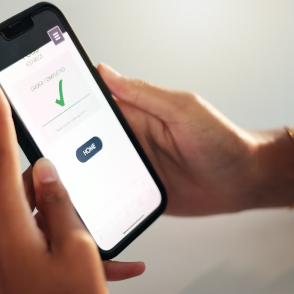 A user holding a phone displaying a green checkmark